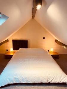 - un grand lit blanc dans un grenier avec deux lumières dans l'établissement Camus Flats, à Bruxelles