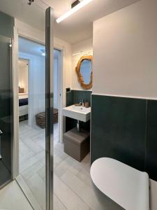 ein Badezimmer mit einem Waschbecken, einem WC und einem Spiegel in der Unterkunft Cozy APT town centre, 2BTH and garage in Breuil-Cervinia