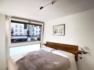 ein Schlafzimmer mit einem Bett und einem großen Fenster in der Unterkunft Cozy APT town centre, 2BTH and garage in Breuil-Cervinia