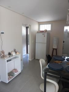 een keuken met een tafel en een witte koelkast bij Apartamento 2 quartos 200 m da praia in Lauro de Freitas