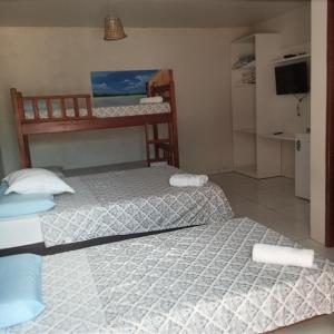 two twin beds in a room with a kitchen at Pousada Sorriso da Mata.. in Alter do Chao