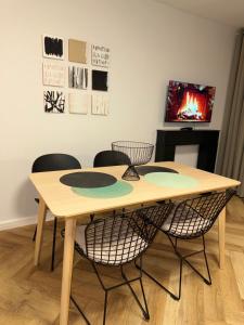 een tafel met stoelen en een televisie in een kamer bij AlmaOldTown - Centrum - Check-In 24h in Wrocław