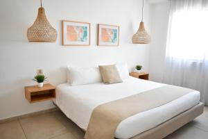 een slaapkamer met een wit bed en 2 hanglampen bij Terrasse Hotel Playa del Carmen in Playa del Carmen