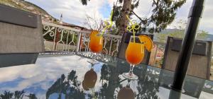 trois verres de jus d'orange assis sur une table en verre dans l'établissement Vila Džan, à Sarajevo