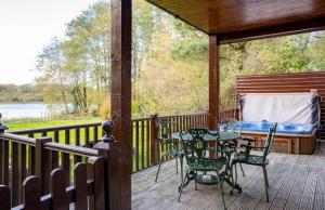 un patio con mesa y sillas en una terraza en Egret Lodge with Hot-tub, en Carlisle