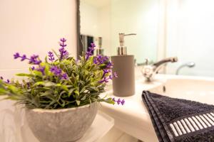 斯利馬的住宿－Sea View Over Valletta Strand Area，浴室的柜台上装有紫色花瓶