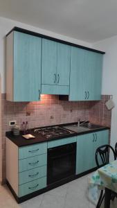 a kitchen with blue cabinets and a stove top oven at Residenza La Dolce Vita in Fronte Aguglieri