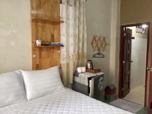 een slaapkamer met een bed, een tafel en een spiegel bij Guest House UTTRANG in Ho Chi Minh-stad