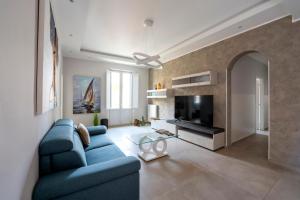 a living room with a blue couch and a tv at Appartamenti La Fenice in Trapani