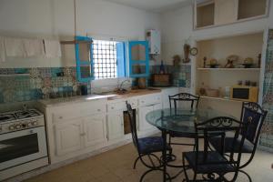 a kitchen with a table and chairs and a stove at Wostel Djerba in Erriadh