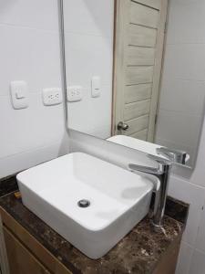 a white sink in a bathroom with a mirror at Hotel Valledupar Plaza in Valledupar