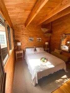 ein Schlafzimmer mit einem Bett in einer Holzhütte in der Unterkunft Vale do Laranjal in Setúbal
