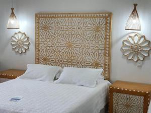 a bedroom with a white bed and a wall art at Hotel Valledupar Plaza in Valledupar