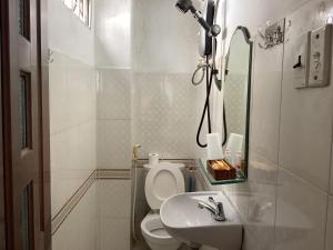 een witte badkamer met een toilet en een wastafel bij Guest House UTTRANG in Ho Chi Minh-stad