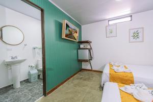 a room with a bed and a bathroom with a mirror at NOMADA HOTEL GUATAPE in Guatapé
