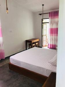 a bedroom with a large bed and a window at Midira Villa in Galle