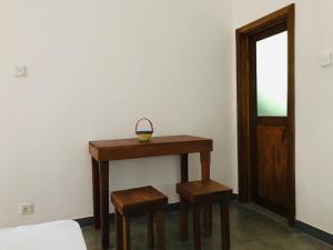 a wooden table with two stools and a basket on it at Midira Villa in Galle