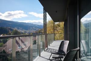 balcón con sillas y vistas a las montañas en Aries Hotel & SPA Szczyrk, en Szczyrk