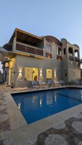 una casa con piscina frente a una casa en Yasmine Guest House en Luxor