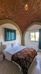a bedroom with a large bed with a brick wall at Yasmine Guest House in Luxor