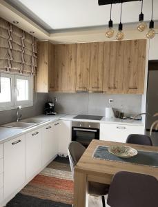 a kitchen with white cabinets and a wooden table at Silver House in Asímion