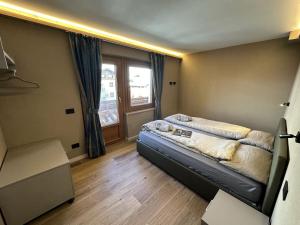 een slaapkamer met een bed en een raam bij La Sorgente Appartamento Martin in Livigno