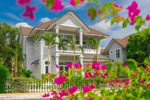 ein Haus mit rosa Blumen davor in der Unterkunft Casa Villa - Floral Park- Sealinks City Resort in Phan Thiet