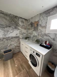 a bathroom with a washing machine and a sink at Silver House in Asímion