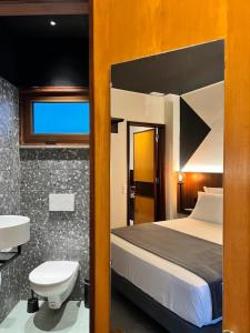 a bedroom with a bed and a toilet and a sink at Alto House Faro AL de Assinatura Modernista in Faro