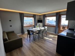 een woonkamer met een tafel, stoelen en een bank bij La Sorgente Appartamento Martin in Livigno