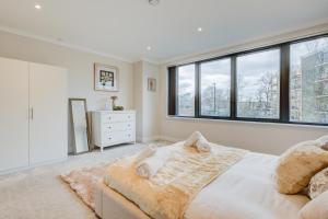 a bedroom with a large bed and large windows at Concord House in Brentford