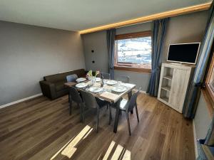 een eetkamer met een tafel en een bank bij La Sorgente Appartamento Martin in Livigno