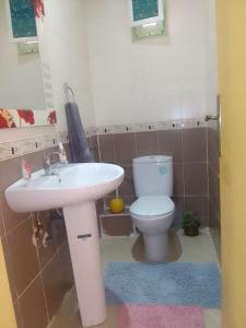 La salle de bains est pourvue d'un lavabo blanc et de toilettes. dans l'établissement Angel Appartement, à Marrakech