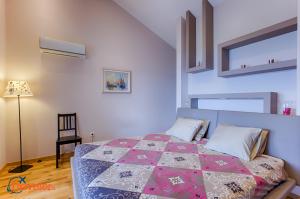 a bedroom with a bed with a quilt on it at New villa with swimming pool, olive grove and sea view by Traveler tourist agency Krk ID 2201 in Brzac +37 photos