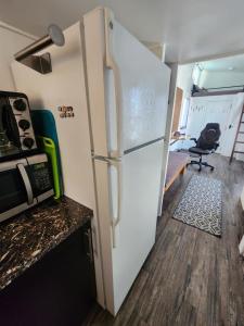 a white refrigerator in a kitchen with a table at Tiny Home Hot Tub in Colorado City