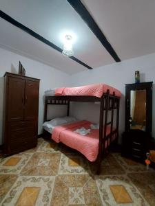 a bedroom with a bunk bed and a dresser at Hostal Posada Del Corazón in Salento