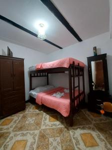 a bedroom with two bunk beds and a mirror at Hostal Posada Del Corazón in Salento