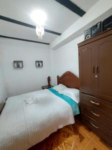 a bedroom with a large bed and a dresser at Hostal Posada Del Corazón in Salento