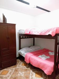 a bedroom with two bunk beds and a dresser at Hostal Posada Del Corazón in Salento