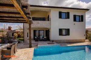 a villa with a swimming pool and a house at New villa with swimming pool, olive grove and sea view by Traveler tourist agency Krk ID 2201 in Brzac