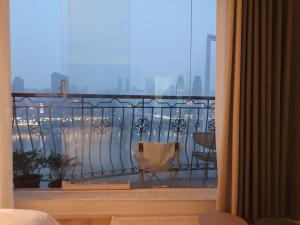 a room with a balcony with a view of the city at Comacros - Chongqing JieFang Cave River View Apartment - Line 1 and Line 2 Jiachangkou Subway Station in Chongqing