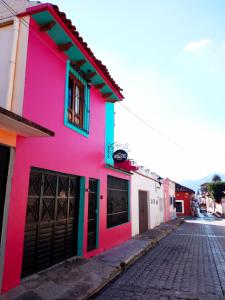 un edificio colorido al lado de una calle en Kaza Muta en San Cristóbal de Las Casas