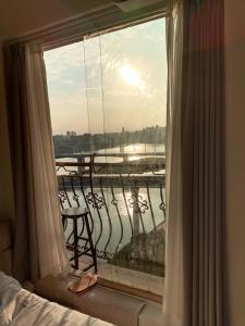 a bedroom with a window with a view of a river at Comacros - Chongqing JieFang Cave River View Apartment - Line 1 and Line 2 Jiachangkou Subway Station in Chongqing