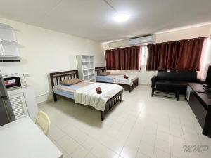 een kamer met 2 bedden, een bank en een bureau bij Popular The best muangthongthani 日常房间公寓 in Ban Bang Phang