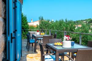 a patio with tables and chairs on a balcony at Marceline in Prvić Luka