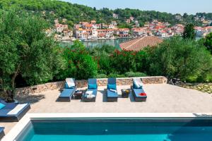 un gruppo di sedie a sdraio e una piscina di Marceline a Prvić Luka (Provicchio)