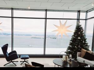 a christmas tree in a room with a large window at Pepsitoppen Villa in Tau