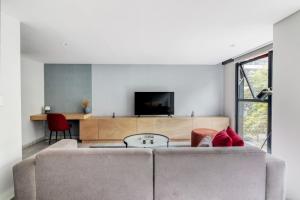 a living room with a couch and a tv at JVM 421, in Polanco by Blueground in Mexico City