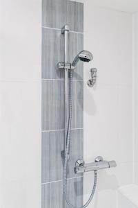 a shower with a shower head in a bathroom at Haus-Gotland-Wohnung-10 in Westerland