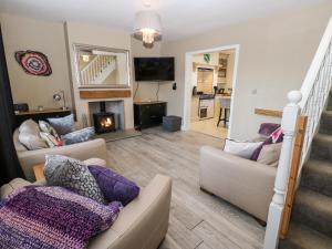 sala de estar con 2 sofás y chimenea en Hazel Cottage, en Keighley